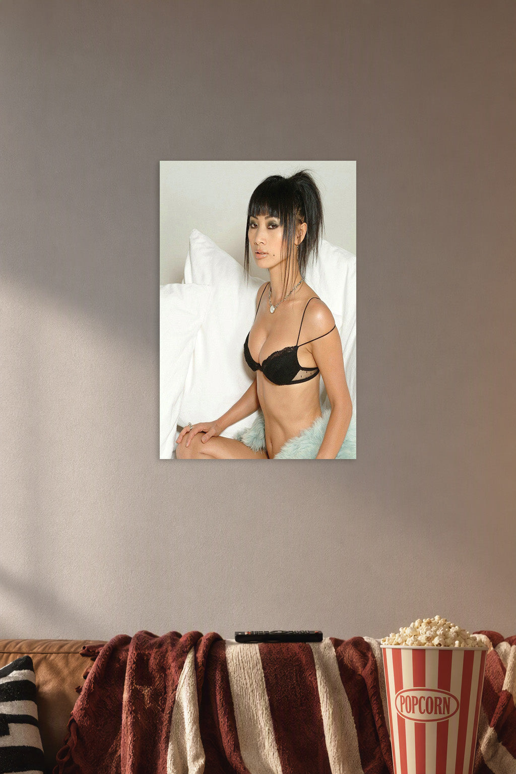 Glamorous Asian Woman in a cozy movie room above a brown sofa with popcorn.