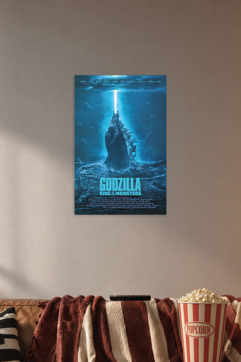 Godzilla King of the Monsters in a cozy movie room above a brown sofa with popcorn.
