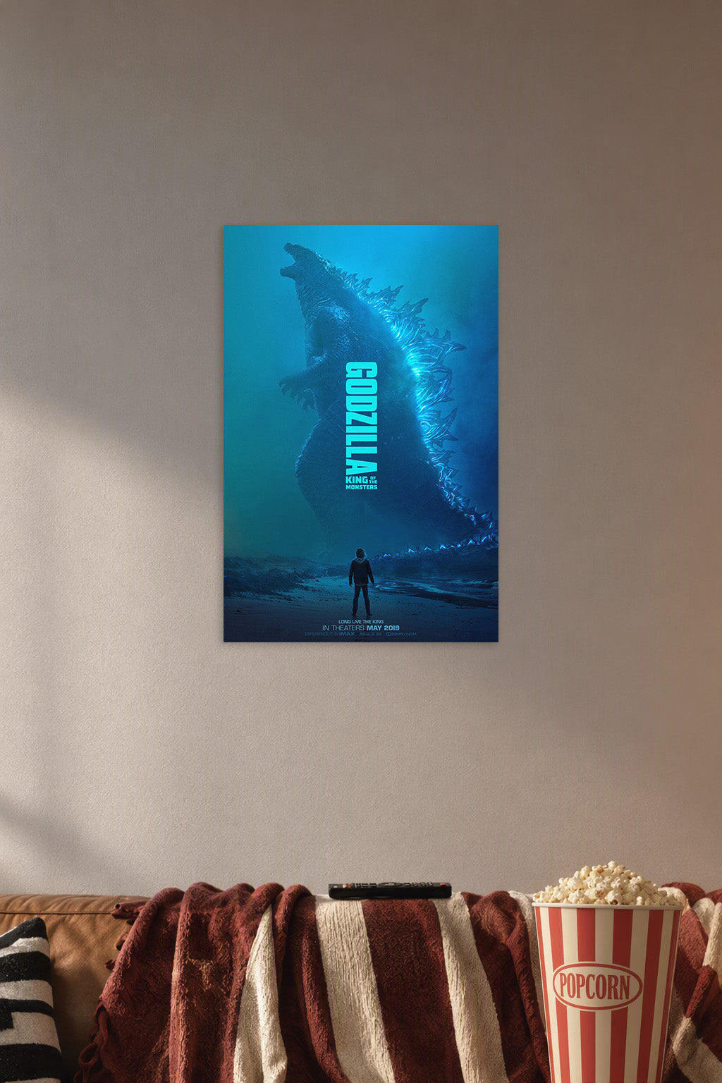 Godzilla: King of the Monsters in a cozy movie room above a brown sofa with popcorn.