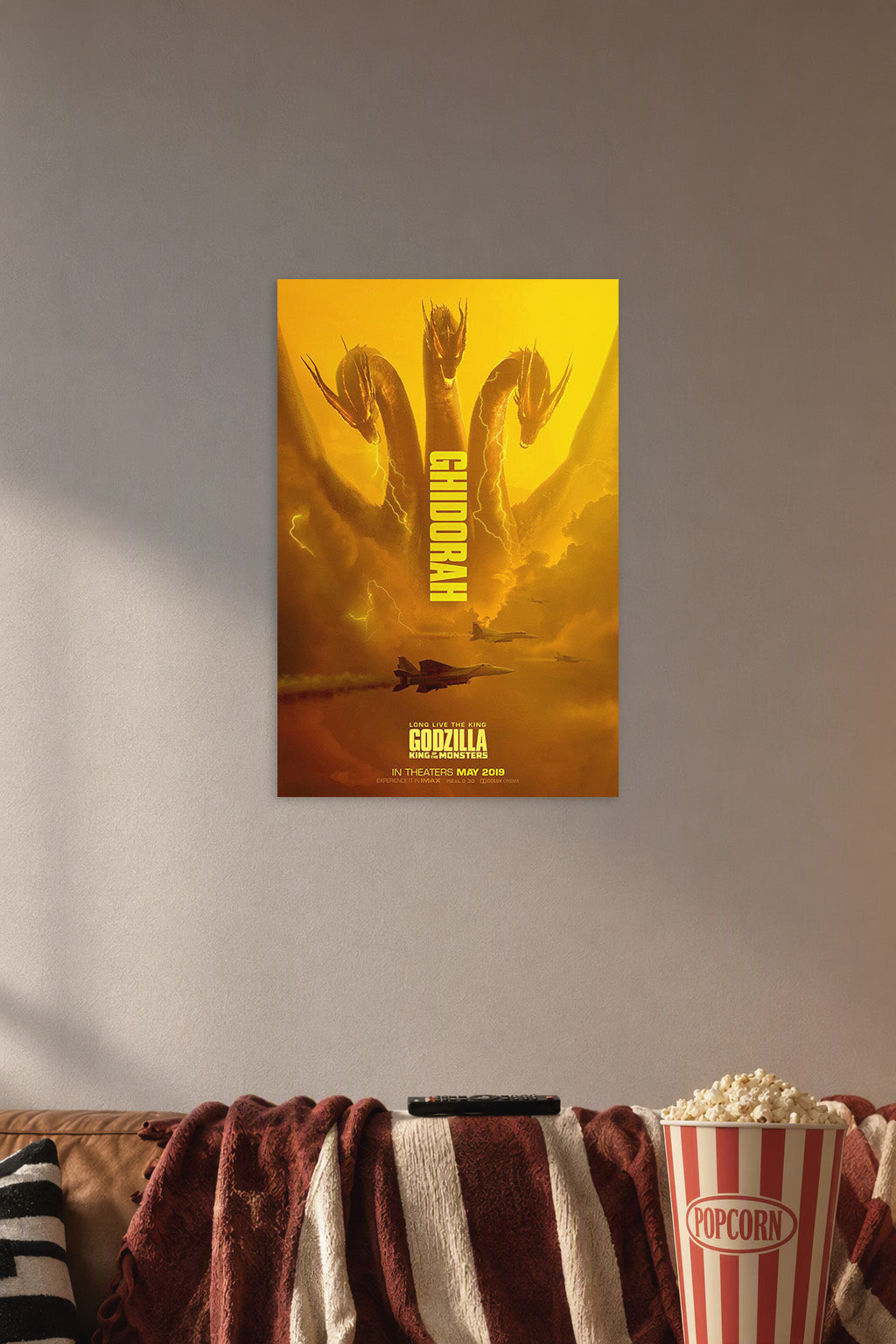 Godzilla King of the Monsters King Ghidorah Movie Poster in a cozy movie room above a brown sofa with popcorn.
