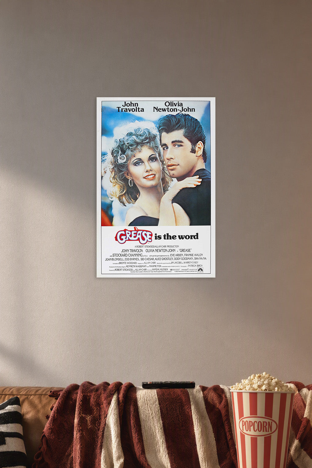 Grease Movie John Travolta Olivia Newton-John in a cozy movie room above a brown sofa with popcorn.