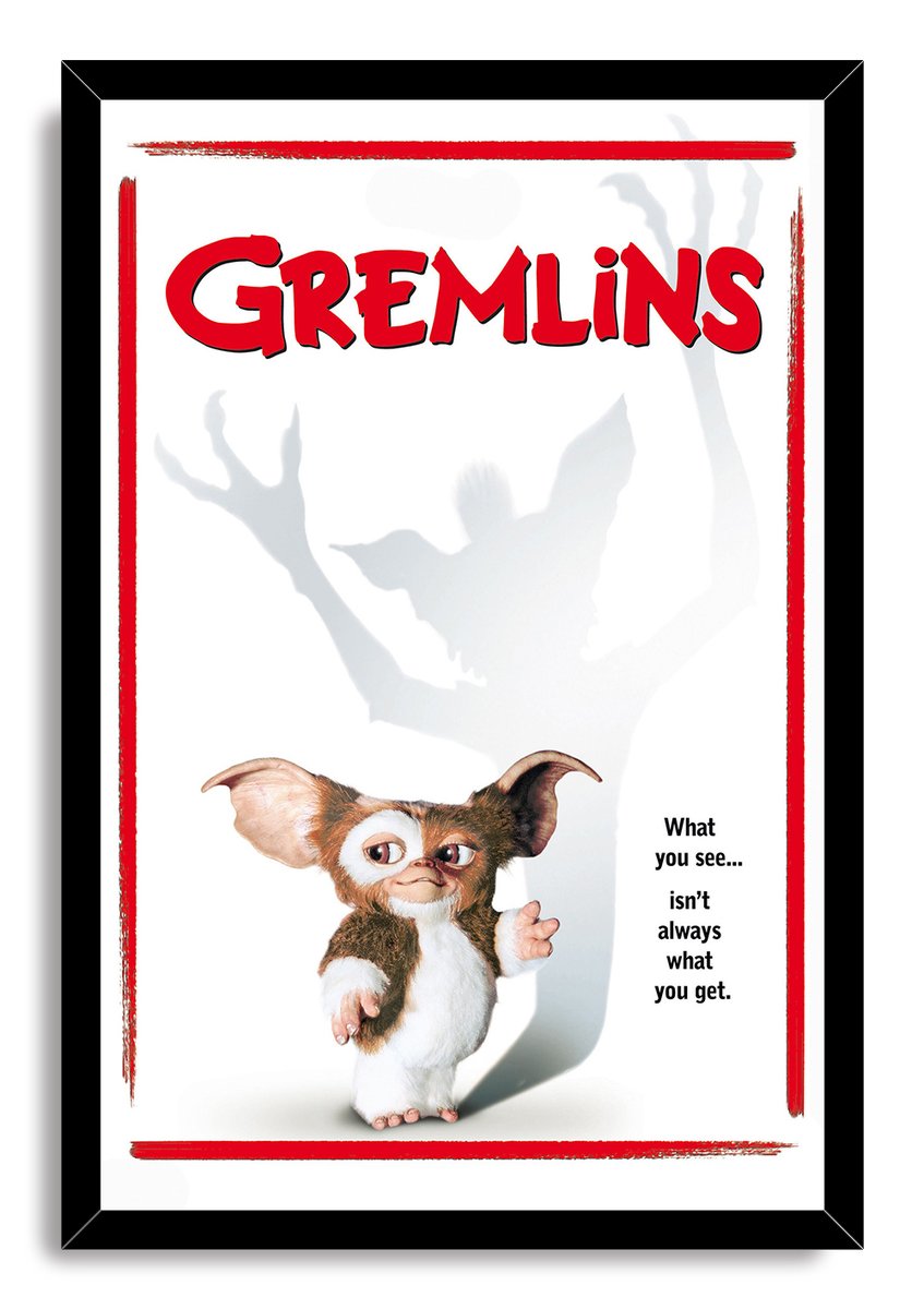 Gremlins framed wall art print features Gizmo, a towering gray Gremlin shadow, red title text, and a black frame.
