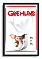 Gremlins framed wall art print features Gizmo, a towering gray Gremlin shadow, red title text, and a black frame.