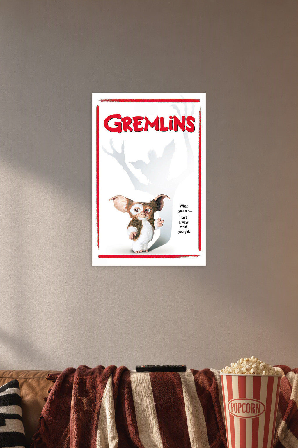 Gremlins in a cozy movie room above a brown sofa with popcorn.