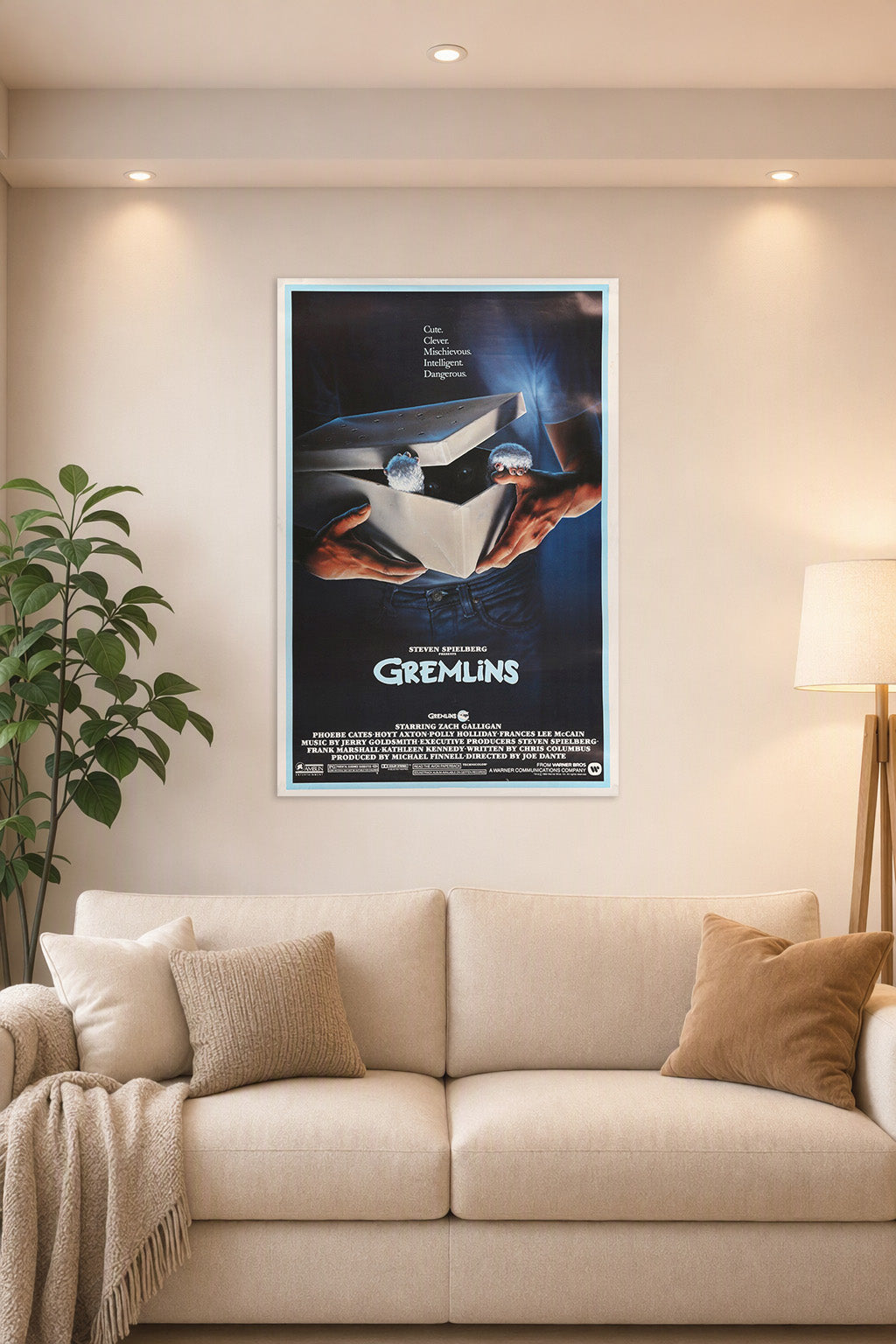 Gremlins Movie Poster in a bright living room above a beige sofa.