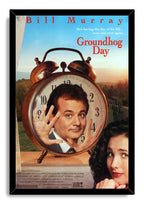 Groundhog Day framed wall art print presents Bill Murray in a giant alarm clock, Andie MacDowell at the edge, and red title lettering.