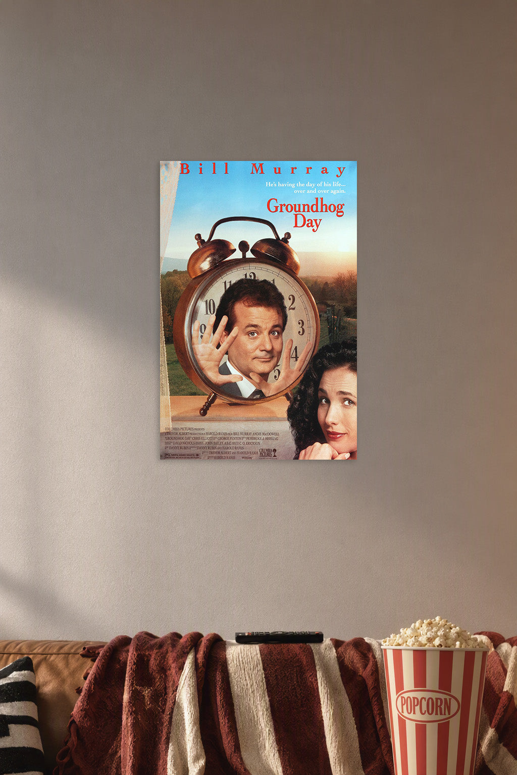 Groundhog Day Bill Murray Andie MacDowell in a cozy movie room above a brown sofa with popcorn.