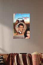 Groundhog Day Bill Murray Andie MacDowell in a cozy movie room above a brown sofa with popcorn.