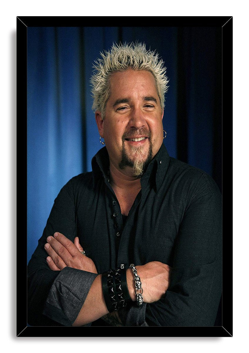 Guy Fieri framed wall art print features a smiling portrait in a glossy black frame, with crossed arms and a blue background.