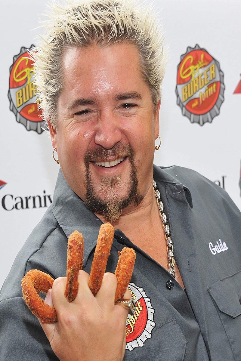 Guy Fieri poster features the smiling chef with spiky blond hair, a gray shirt, and fried snacks held over his fingers.