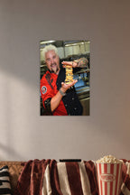 Guy Fieri in a cozy movie room above a brown sofa with popcorn.