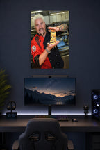 Guy Fieri in a gaming desk setup above a monitor.