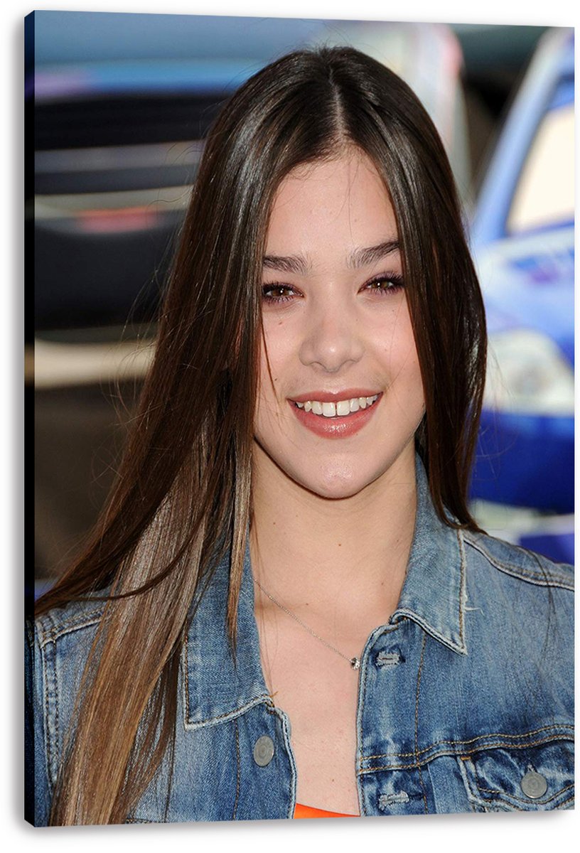 Hailee Steinfeld canvas wall art print featuring her smiling in a denim jacket against a softly blurred blue vehicle backdrop.