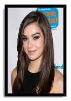 Hailee Steinfeld framed wall art print featuring her smiling in a black top against a white backdrop, set in a black frame.