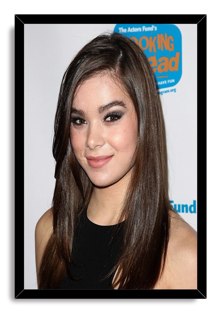 Hailee Steinfeld framed wall art print featuring her smiling in a black top against a white backdrop, set in a black frame.