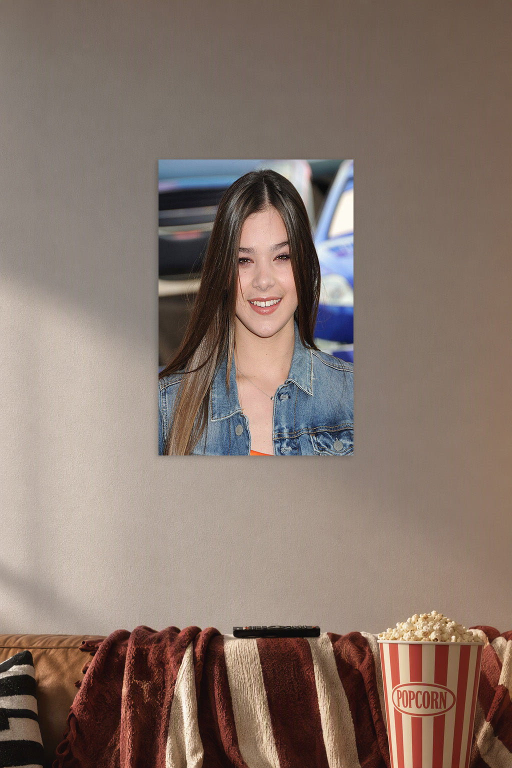 Hailee Steinfeld in a cozy movie room above a brown sofa with popcorn.