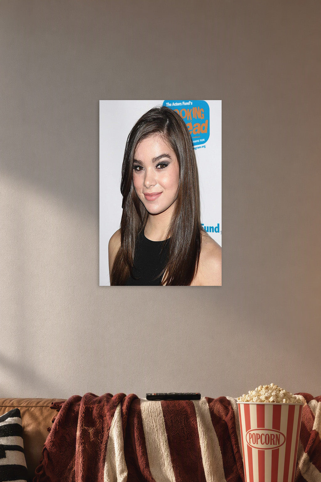 Hailee Steinfeld in a cozy movie room above a brown sofa with popcorn.