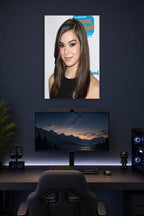 Hailee Steinfeld in a gaming desk setup above a monitor.