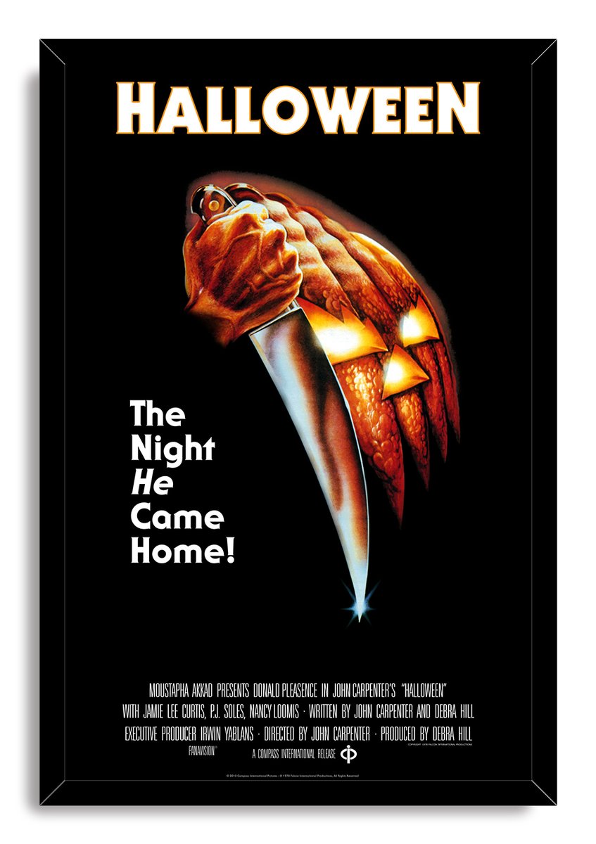 Halloween framed wall art print in a black mitered frame, with a hand-held knife and illuminated orange jack-o'-lantern.