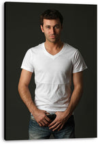 Handsome man canvas wall art print presents a full-length studio portrait of a man in a white T-shirt and jeans on a dark background.