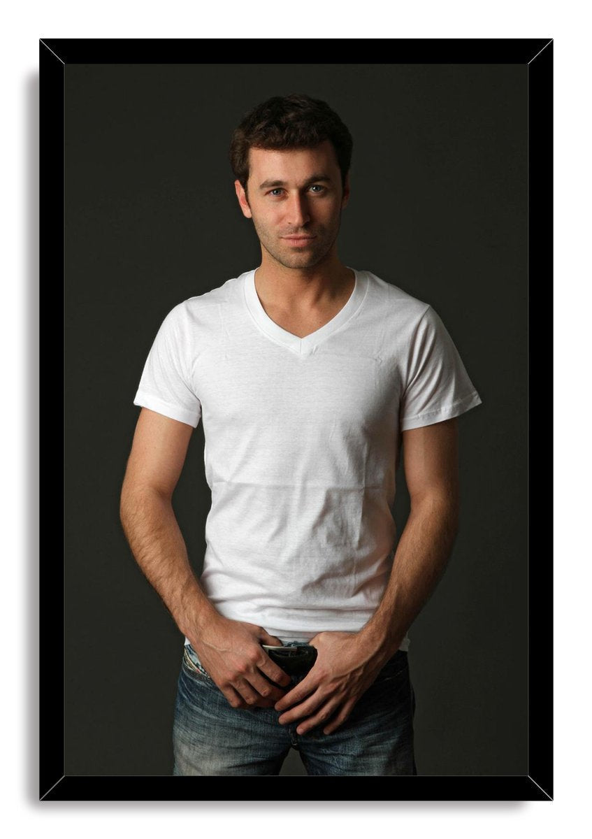 Handsome man framed wall art print features a dark-haired man wearing a white V-neck shirt and blue jeans against a charcoal backdrop.