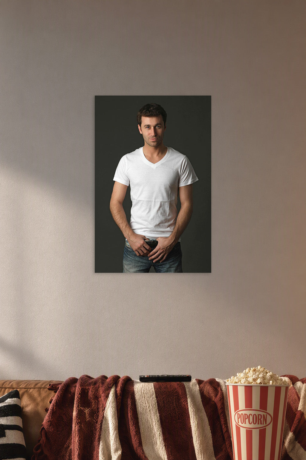 Handsome Man in a cozy movie room above a brown sofa with popcorn.