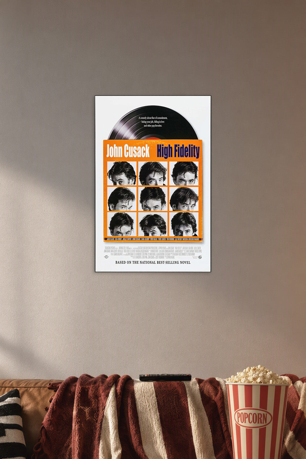 High Fidelity John Cusack in a cozy movie room above a brown sofa with popcorn.
