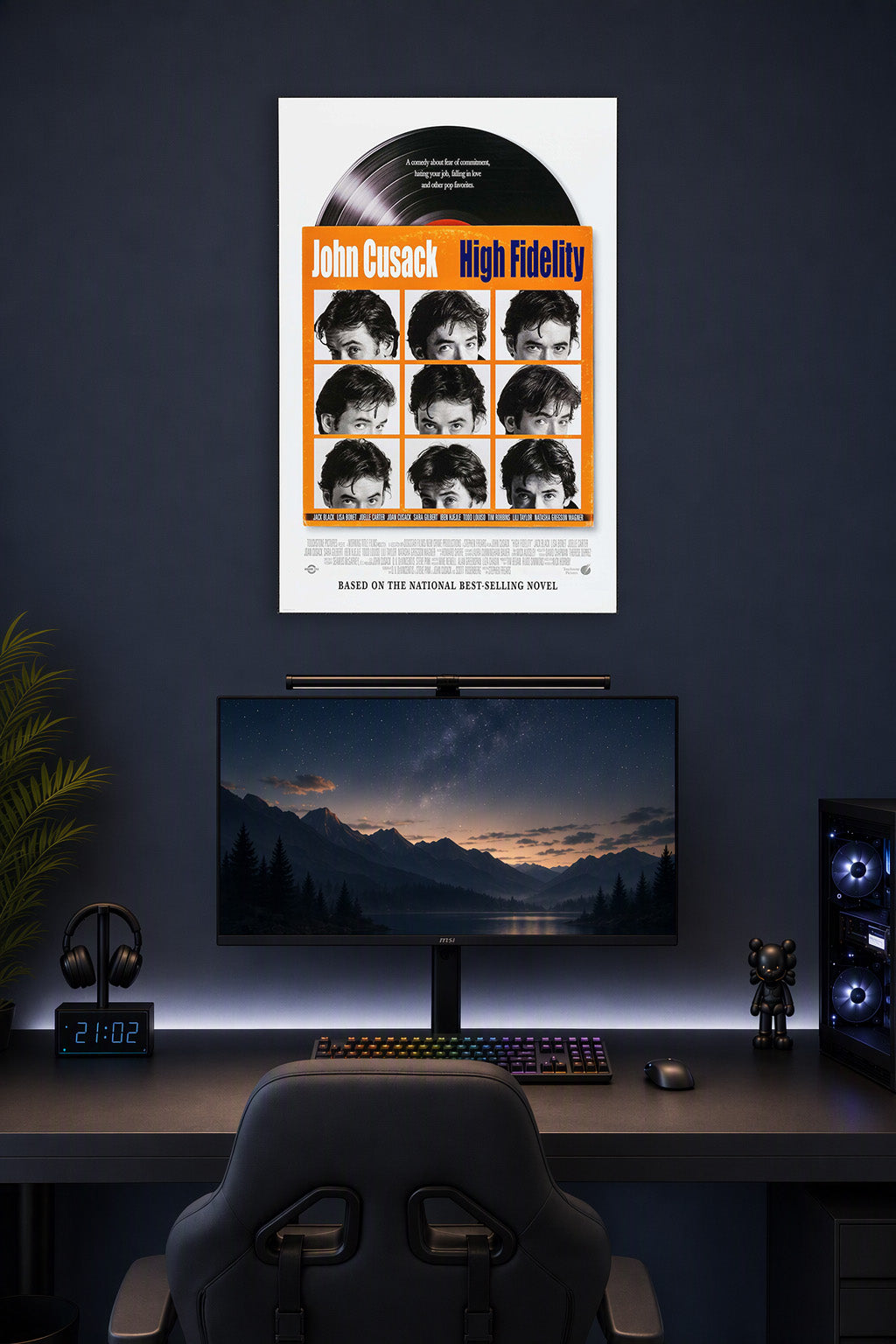 High Fidelity John Cusack in a gaming desk setup above a monitor.