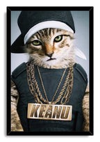 Framed hip-hop cat wall art print portrays a green-eyed tabby wearing a sideways cap, dark outfit, and large KEANU necklace.