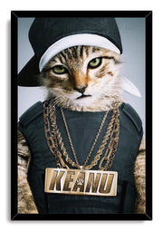Framed hip-hop cat wall art print portrays a green-eyed tabby wearing a sideways cap, dark outfit, and large KEANU necklace.