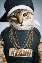 Hip-hop cat wall art print with green eyes, a sideways black cap, dark shirt, gold chains, and a KEANU pendant.