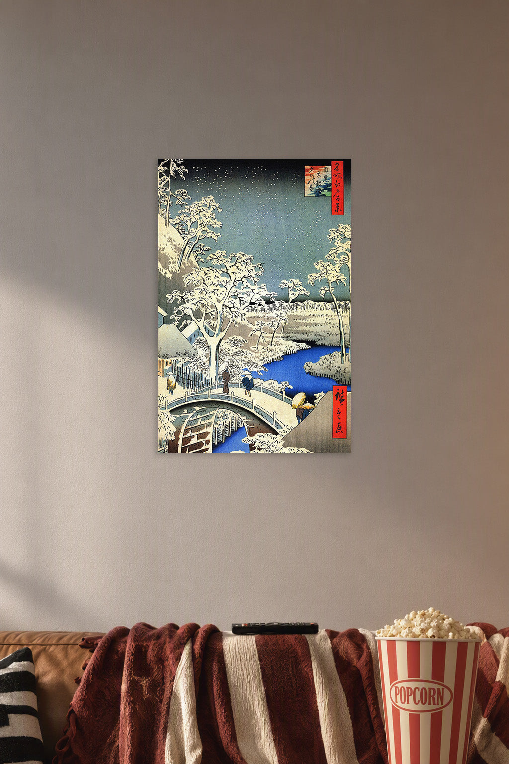 Hiroshige Style Winter Village Snowy Landscape in a cozy movie room above a brown sofa with popcorn.
