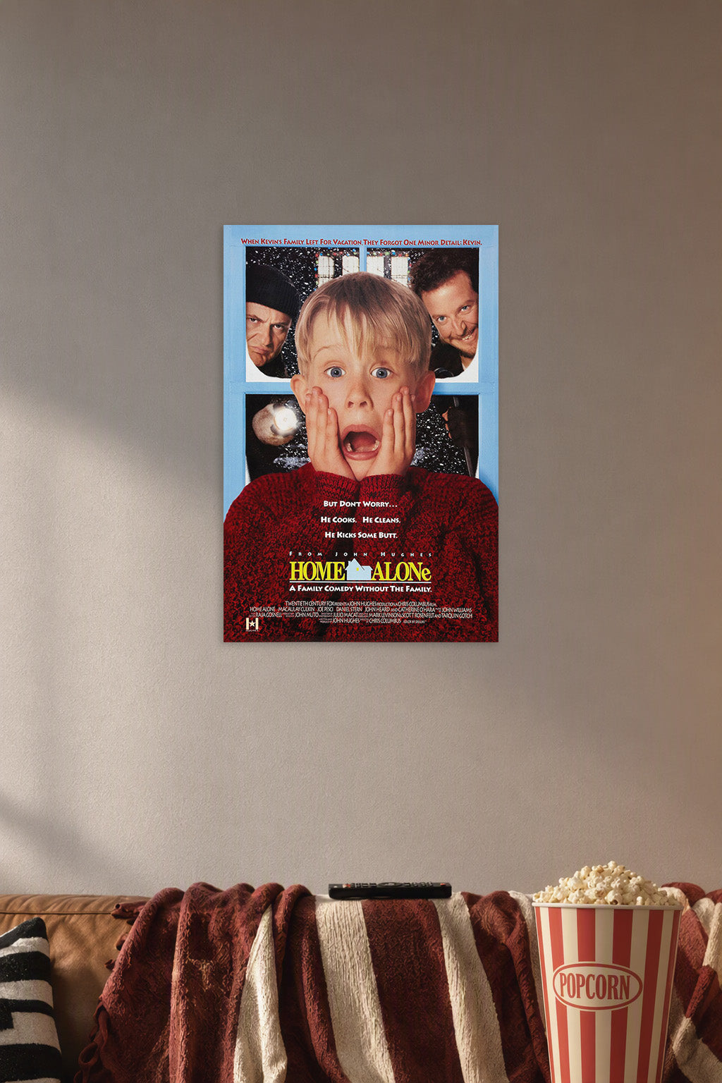 Home Alone Kevin McCallister in a cozy movie room above a brown sofa with popcorn.