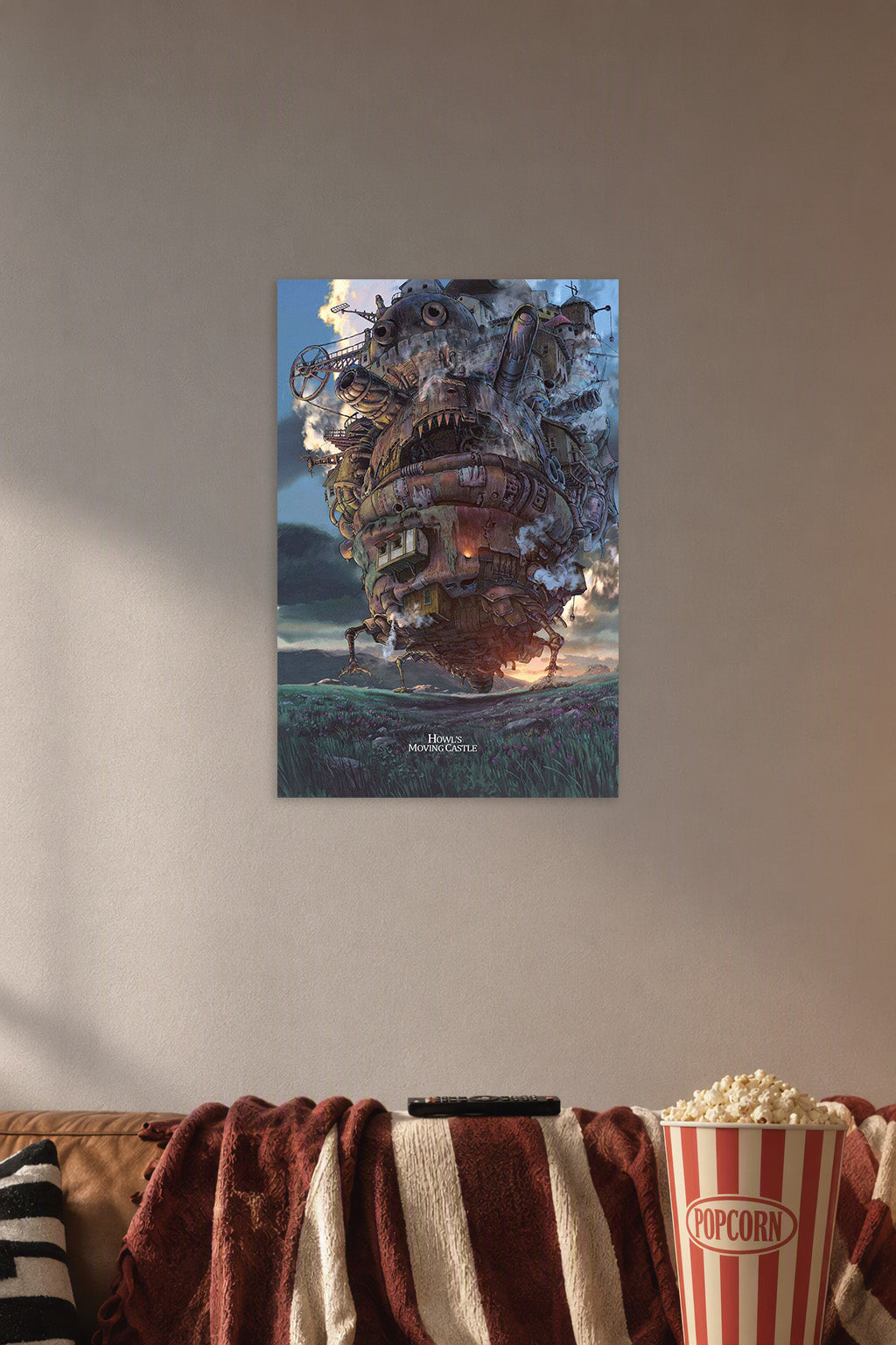 Howl's Moving Castle in a cozy movie room above a brown sofa with popcorn.