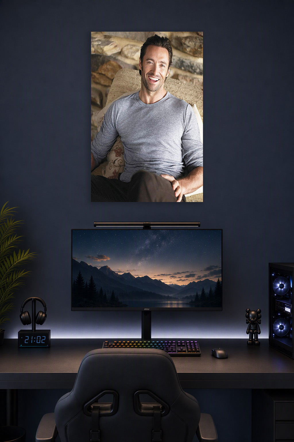 Hugh Jackman in a gaming desk setup above a monitor.