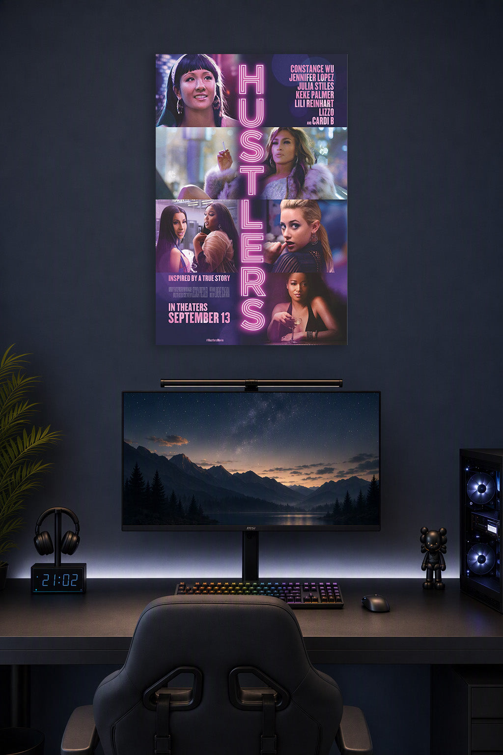 Hustlers Movie Cast in a gaming desk setup above a monitor.