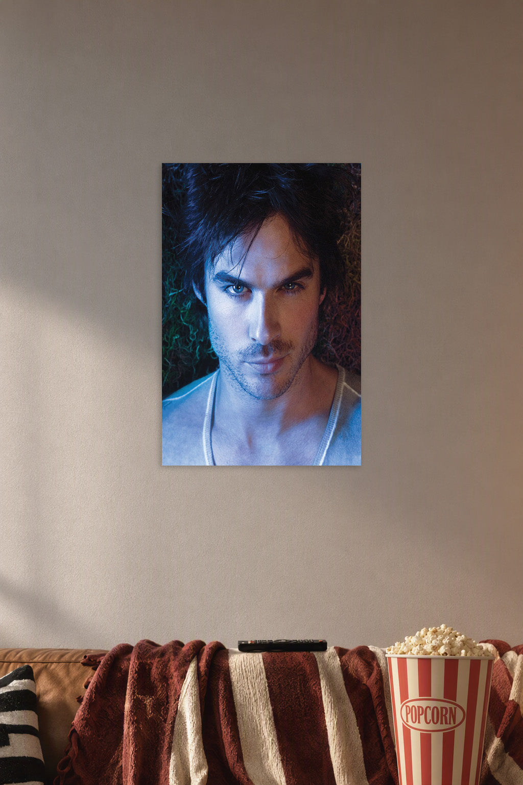 Ian Somerhalder in a cozy movie room above a brown sofa with popcorn.