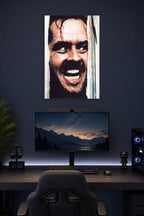 Jack Nicholson The Shining in a gaming desk setup above a monitor.