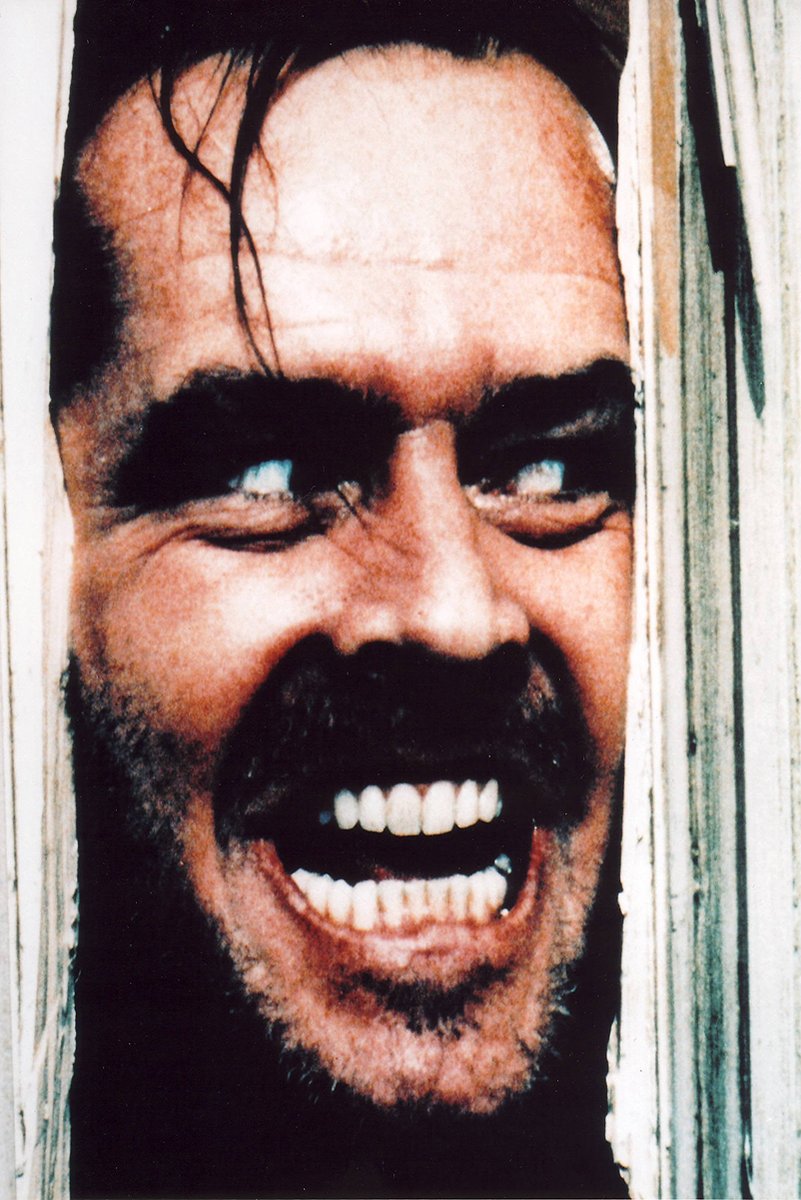 Jack Torrance wall art print from The Shining, with his snarling face pressed through splintered pale wooden door panels.