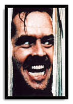 Jack Torrance framed wall art print displays his intense grimacing face through broken white wood in a black frame.