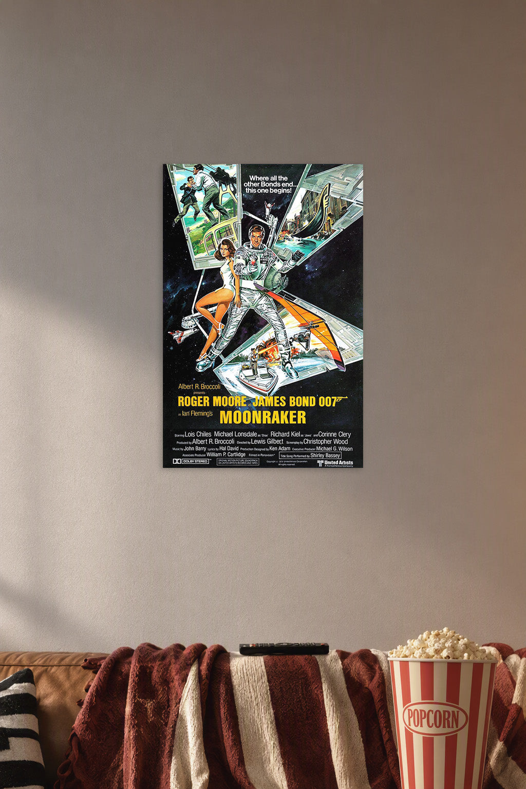 James Bond 007 Moonraker Roger Moore in a cozy movie room above a brown sofa with popcorn.