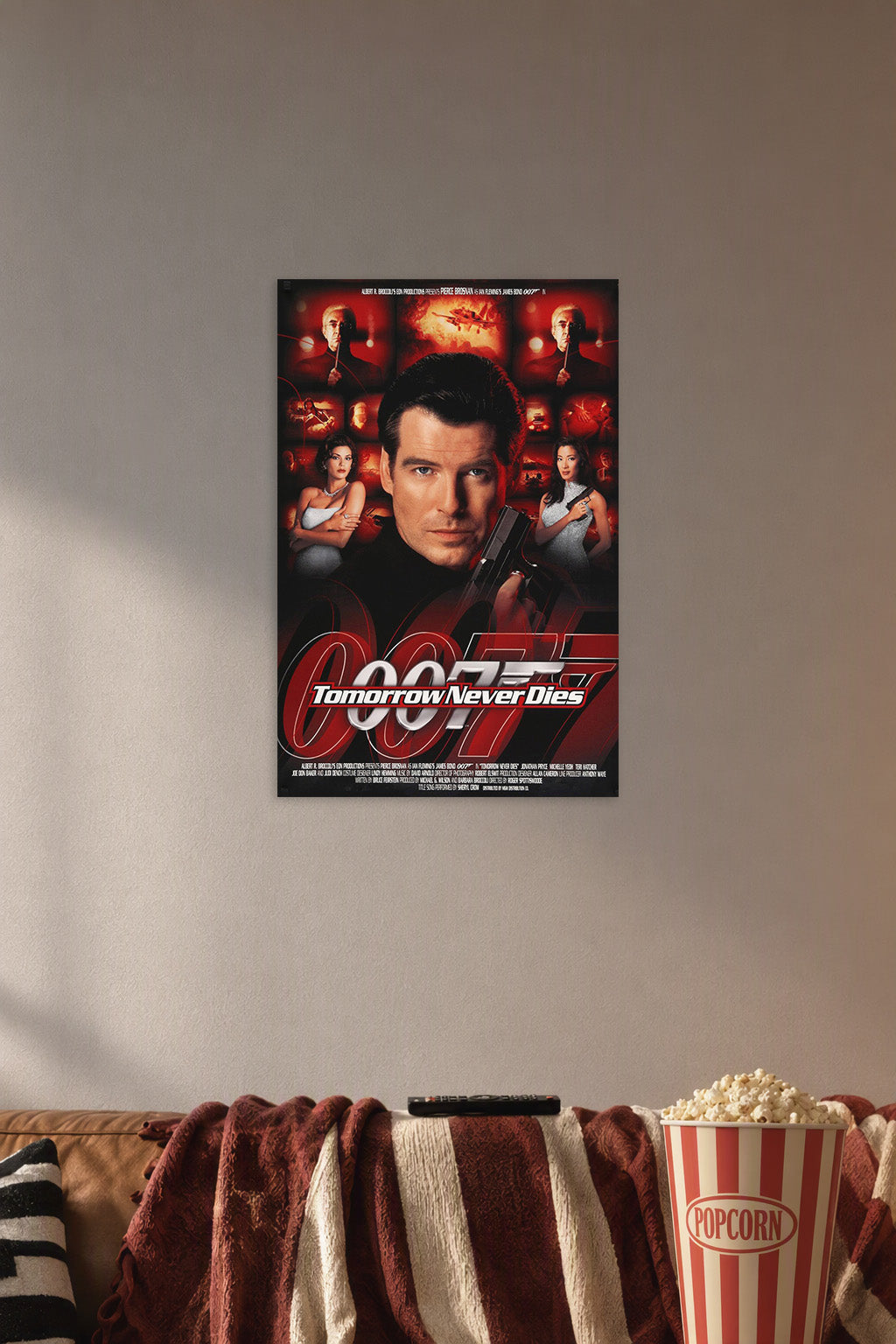 James Bond 007 Tomorrow Never Dies Movie Poster in a cozy movie room above a brown sofa with popcorn.