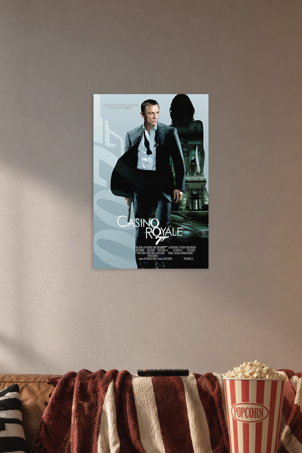 James Bond (Daniel Craig) Casino Royale in a cozy movie room above a brown sofa with popcorn.