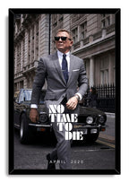 James Bond No Time To Die framed wall art print portrays Daniel Craig in sunglasses and a gray suit in front of a black sports car.