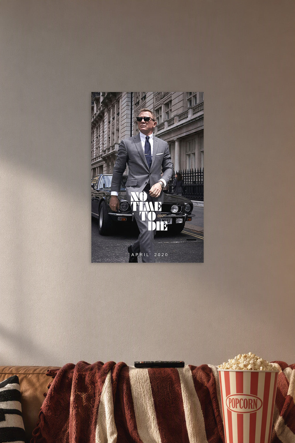 James Bond 'No Time To Die' in a cozy movie room above a brown sofa with popcorn.