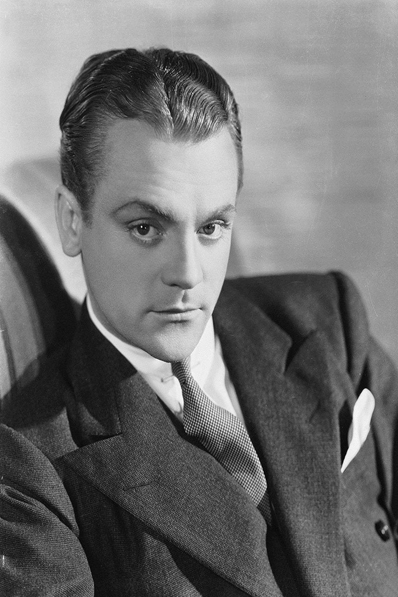 James Cagney wall art print features a black-and-white seated portrait of the actor in a dark suit, tie, and pocket square.