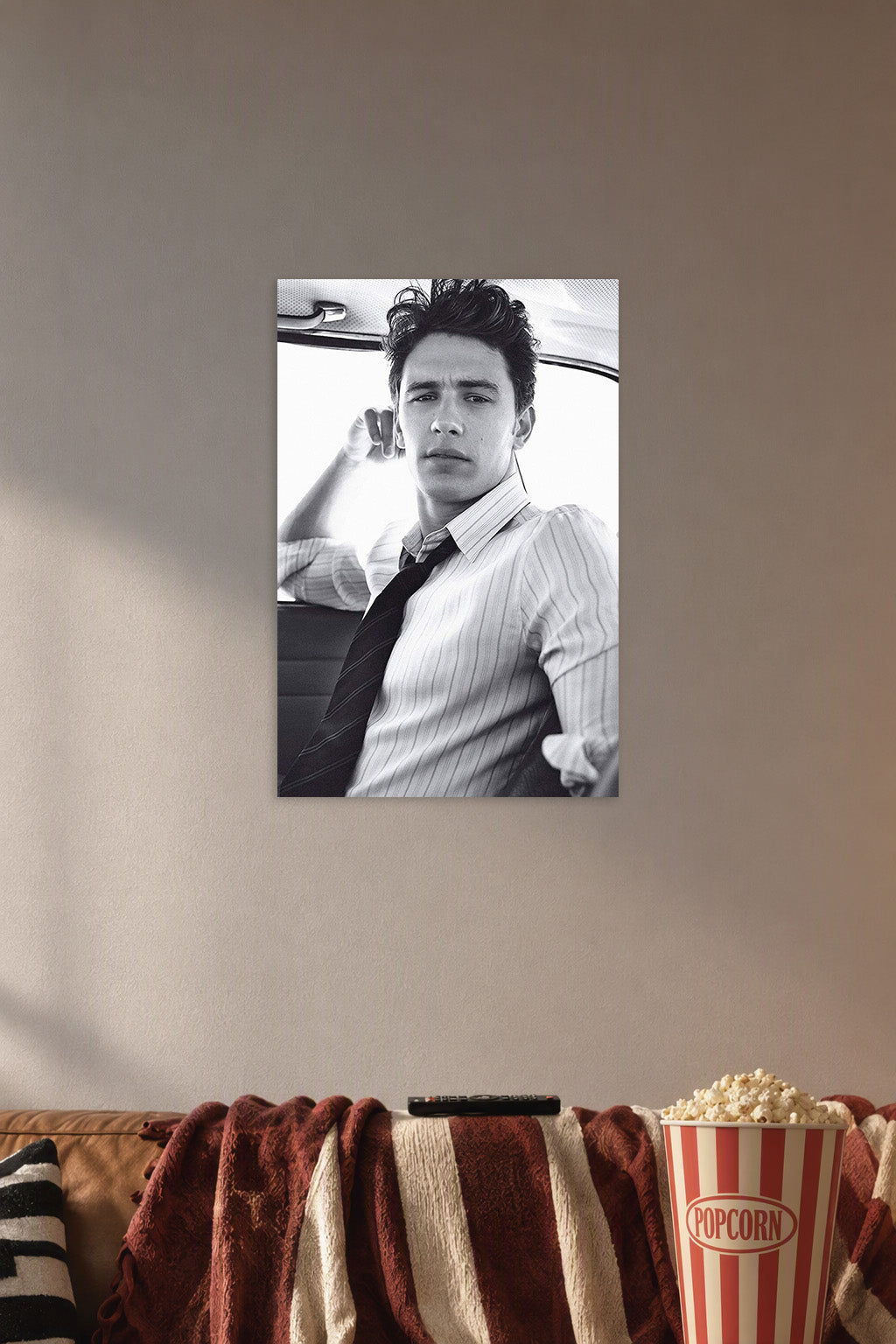 James Franco in a cozy movie room above a brown sofa with popcorn.