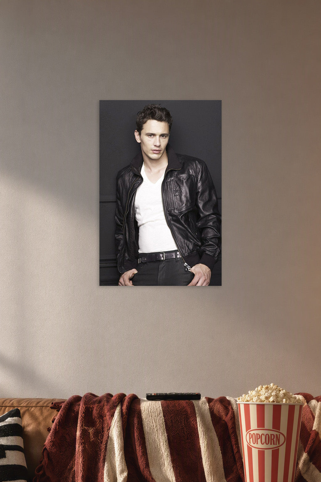 James Franco in a cozy movie room above a brown sofa with popcorn.