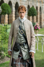 Jamie Fraser poster features a red-haired man in embroidered 18th-century coat and tartan kilt standing in a formal garden.