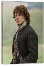 Jamie Fraser canvas wall art print displays Sam Heughan in period clothing, gazing over his shoulder before a muted green and blue outdoor background.